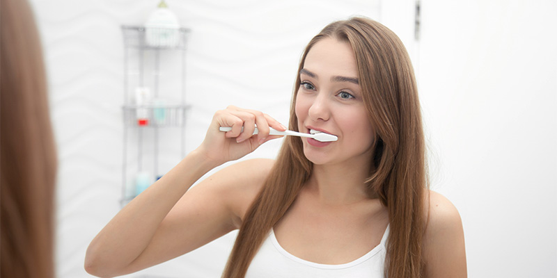 Jeune femme brossage dents